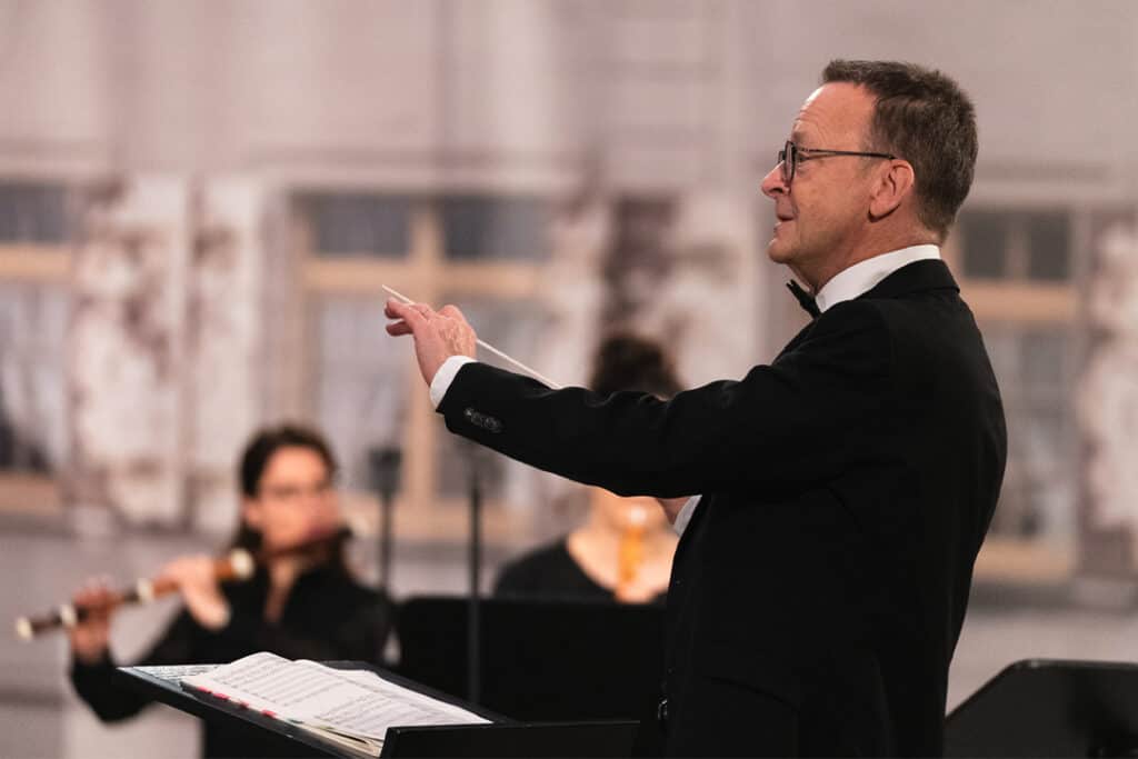 ein Mann im Anzug, der ein Konzert dirigiert